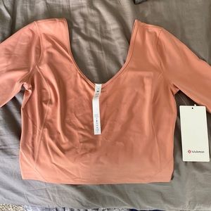 Lululemon crop shirt. NEVER WORN WITH TAGS